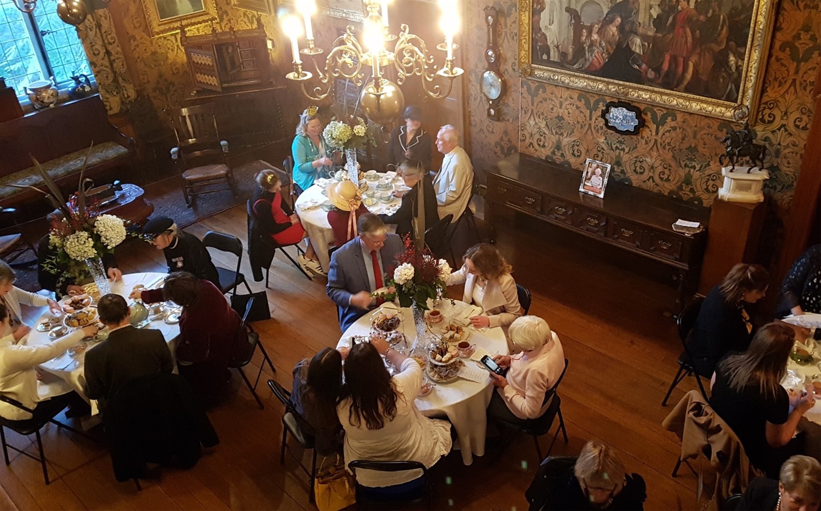 Groups of tables with people sitting and drinking tea